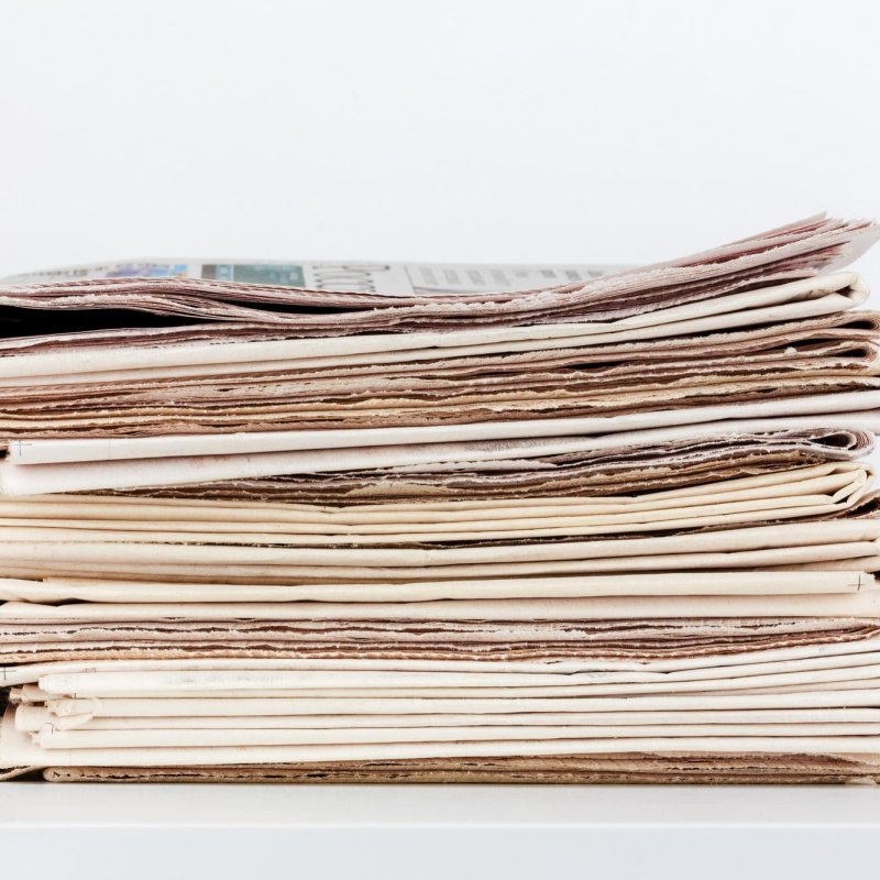 stack of newspapers press release distribution background